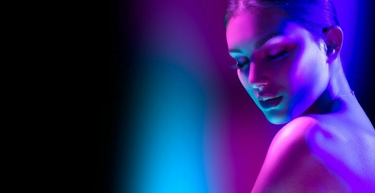 High Fashion model woman in colorful bright neon lights posing i
